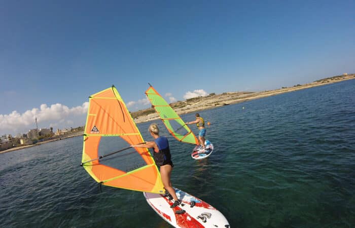 Windsurfer, die während eines Kurses auf Malta Fortschritte machen